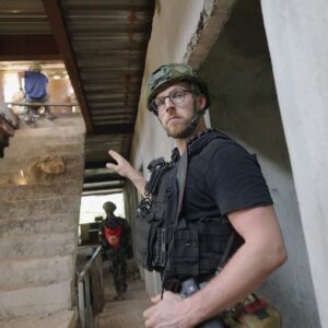 Fabian Janssen mit Helm und Schutzweste in einem zerst&ouml;rten Treppenhaus