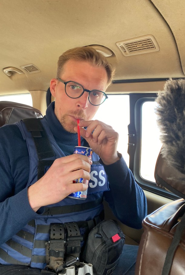 Fabian Janssen mit Presseweste im Auto auf dem Weg zum Dreh